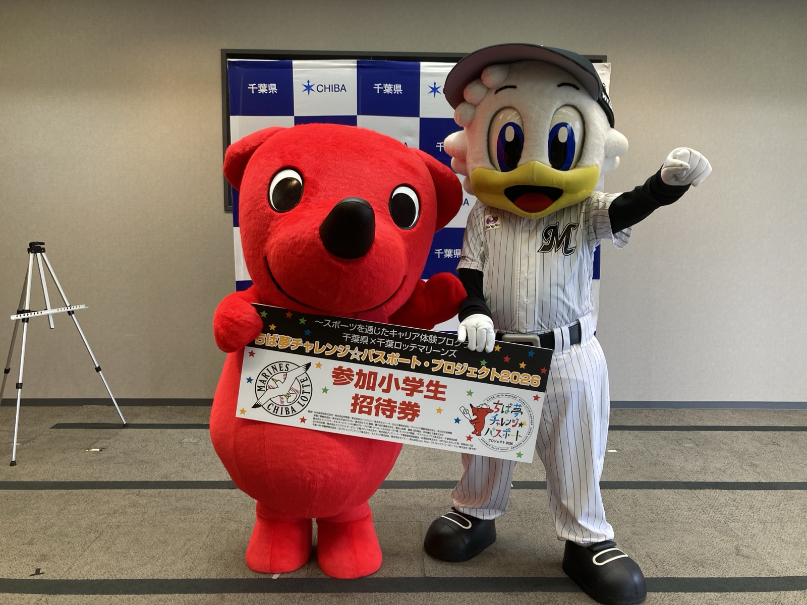 ちば夢チャレンジ☆パスポート・プロジェクトの招待券を掲げるマスコット